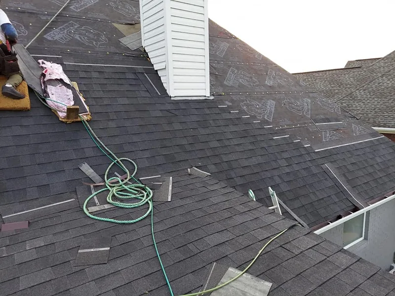 Roofer installing new shingles on a Louisville home